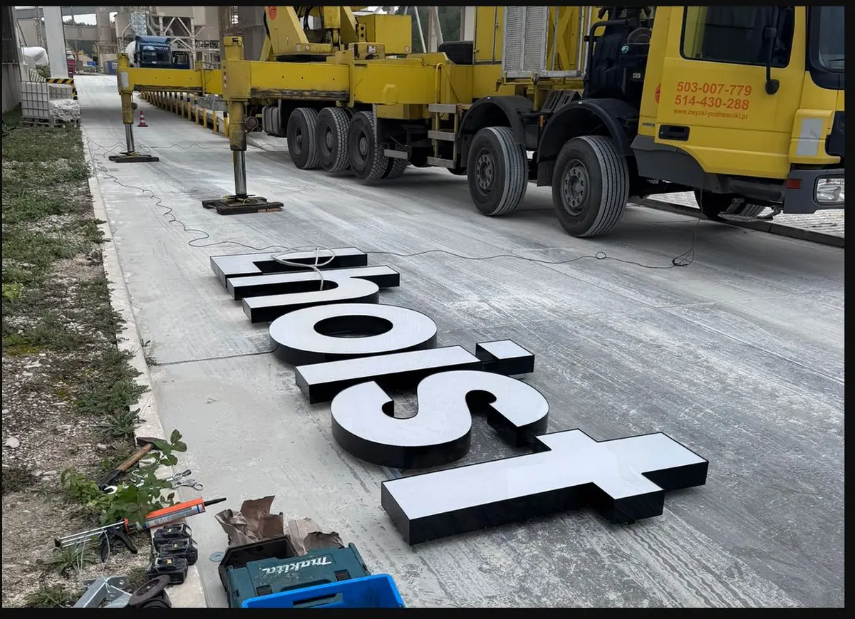 Prostorová 3D písmena LHOIST připravená k montáži v průmyslovém areálu